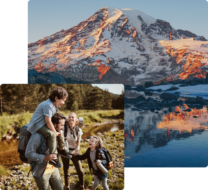 Snow-capped mountain reflecting in a serene lake near a family hiking